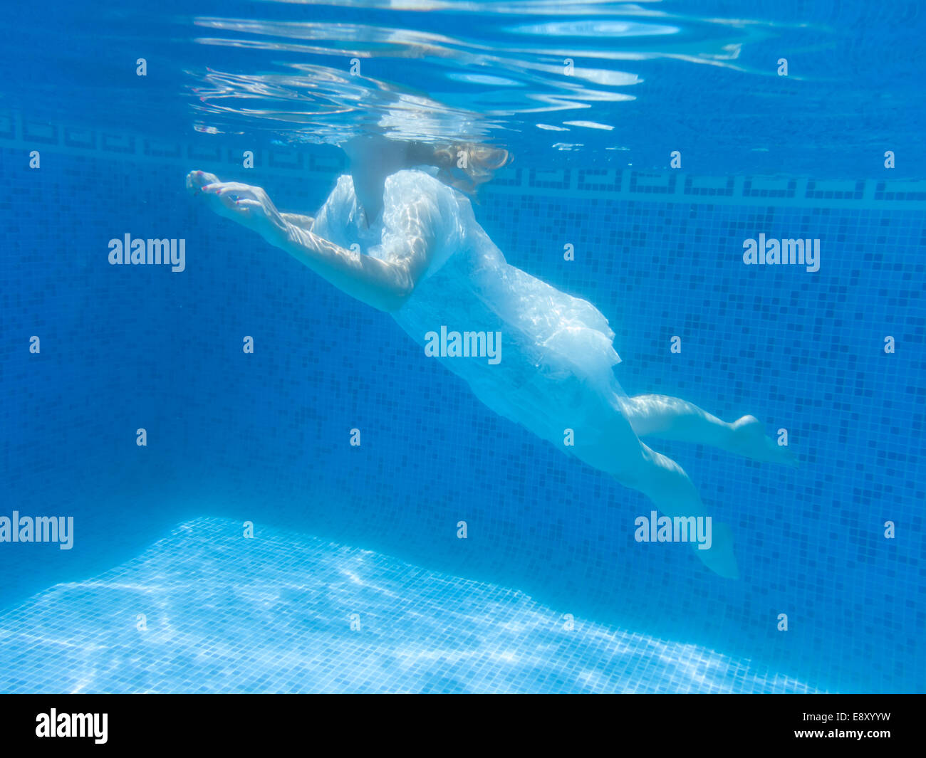 Donna flottante in una piscina Foto Stock