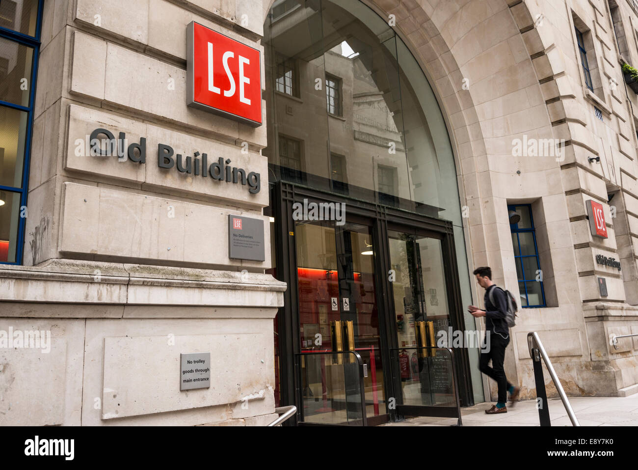 Un giovane studente di sesso maschile a piedi verso l'entrata della LSE vecchio edificio Houghton St in Londra, Regno Unito Foto Stock
