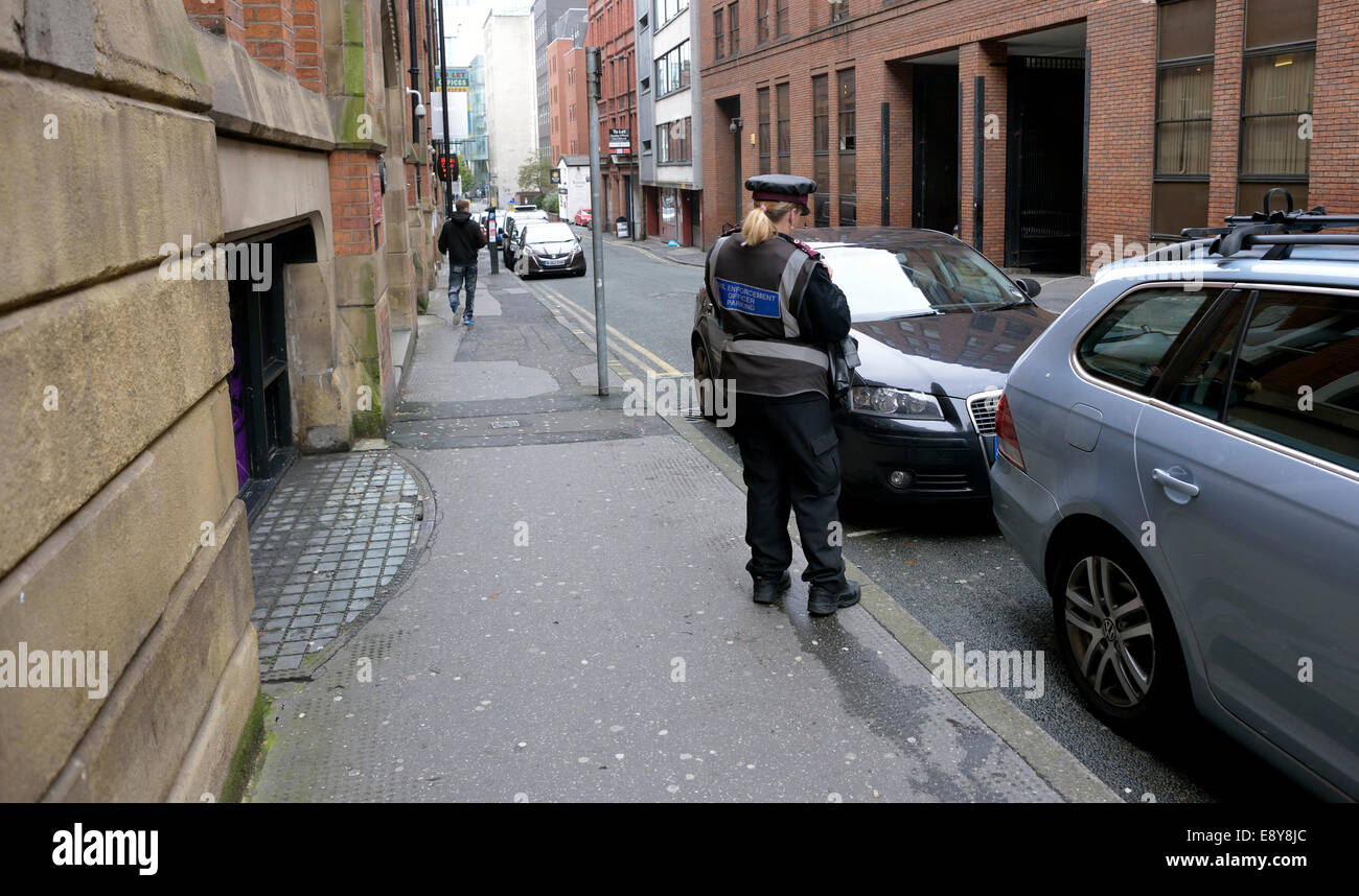 Manchester, Regno Unito. 16 ottobre, 2014. Un parcheggio operaio controlli sulle vetture di Lloyd Street, dove oltre 1700 i biglietti per il parcheggio sono stati rilasciati per il parcheggio illegale dal 2008 al 2013, il quarto più alto per qualsiasi strada in Greater Manchester. Credito: Giovanni friggitrice/Alamy Live News Foto Stock