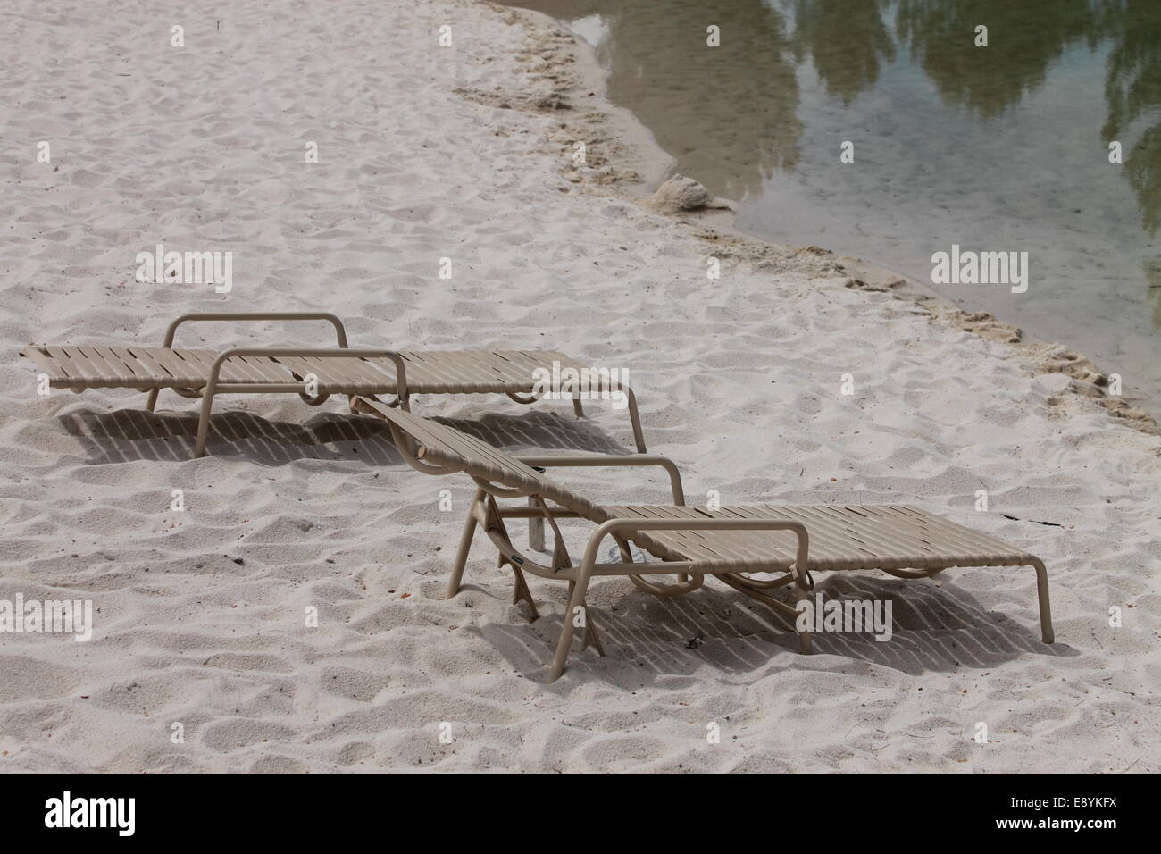 Sedie a sdraio su una spiaggia isolata Foto Stock