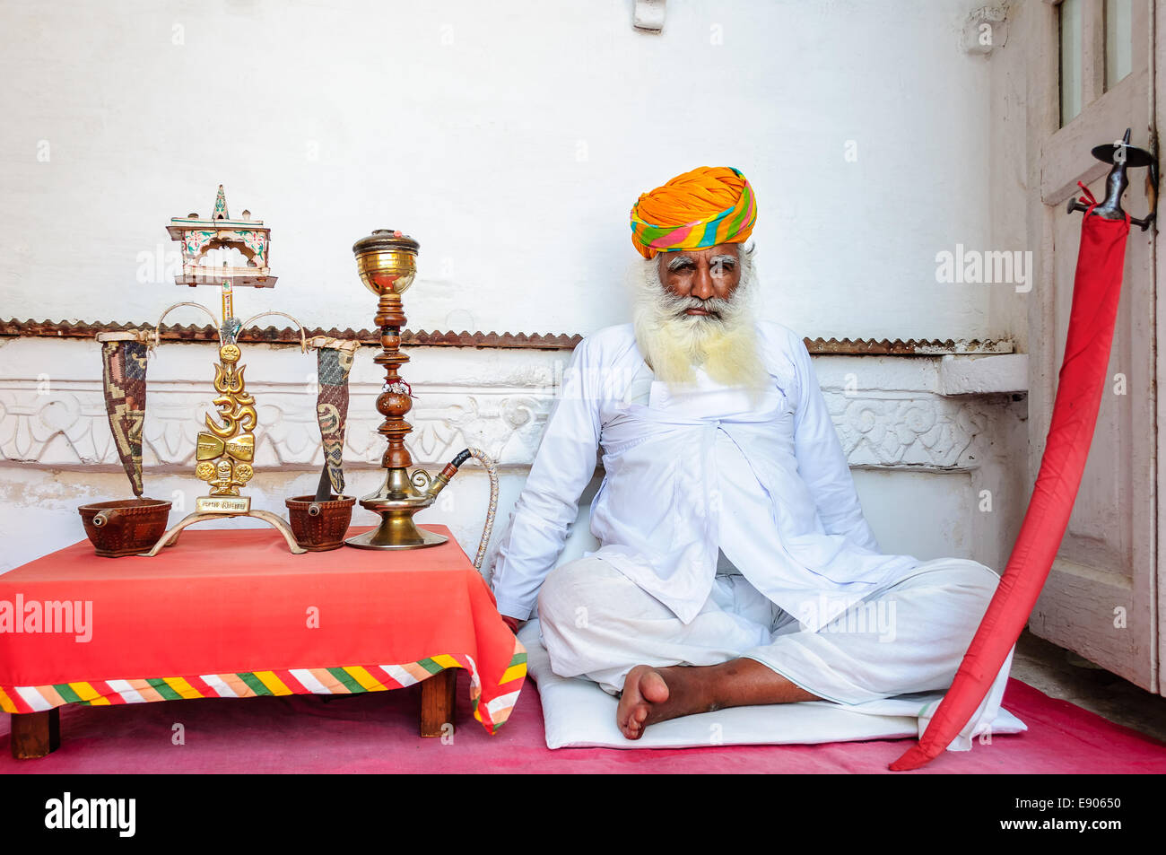 Uomo vecchio con la spada e altri manufatti a Forte Mehrangarh, Jodhpur, Rajasthan Foto Stock