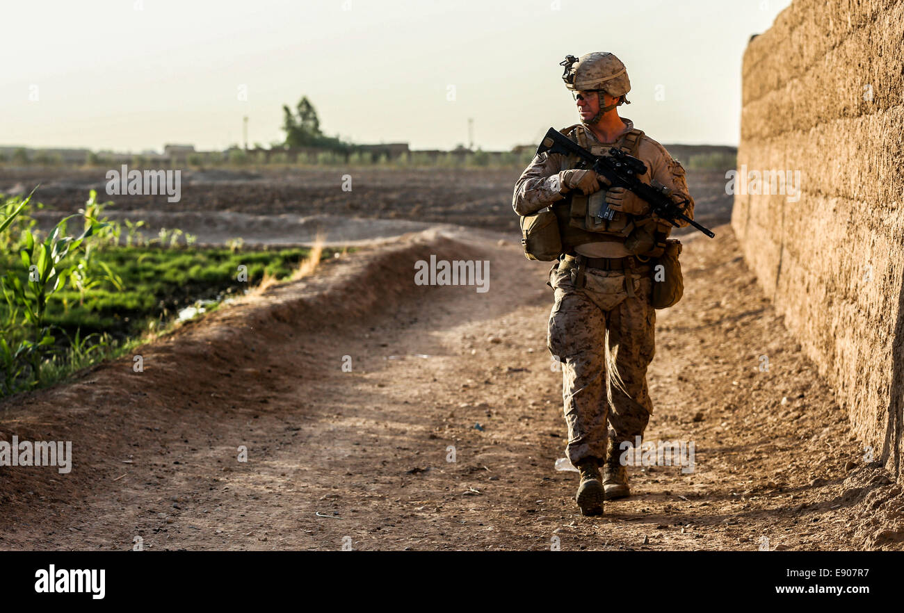 Stati Uniti Marine Corps Lt. Col. Bradley Weston, un comandante del battaglione con il Primo Battaglione, 2° Reggimento Marine, osserva i composti circostanti durante una pattuglia di sicurezza nella provincia di Helmand, Afghanistan, il 7 ottobre 2014. Foto Stock
