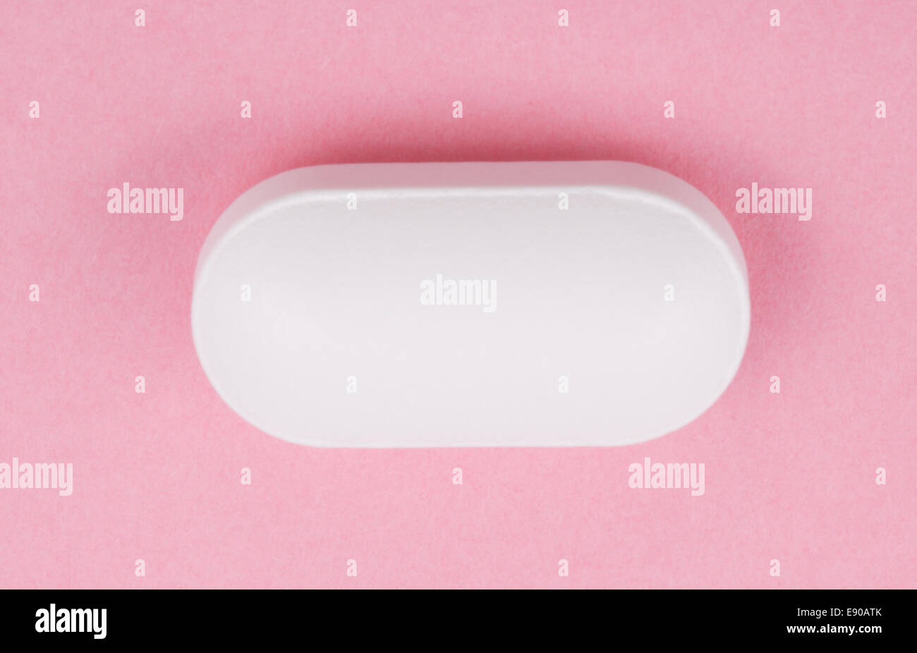 Pillola bianco su sfondo rosa Foto Stock