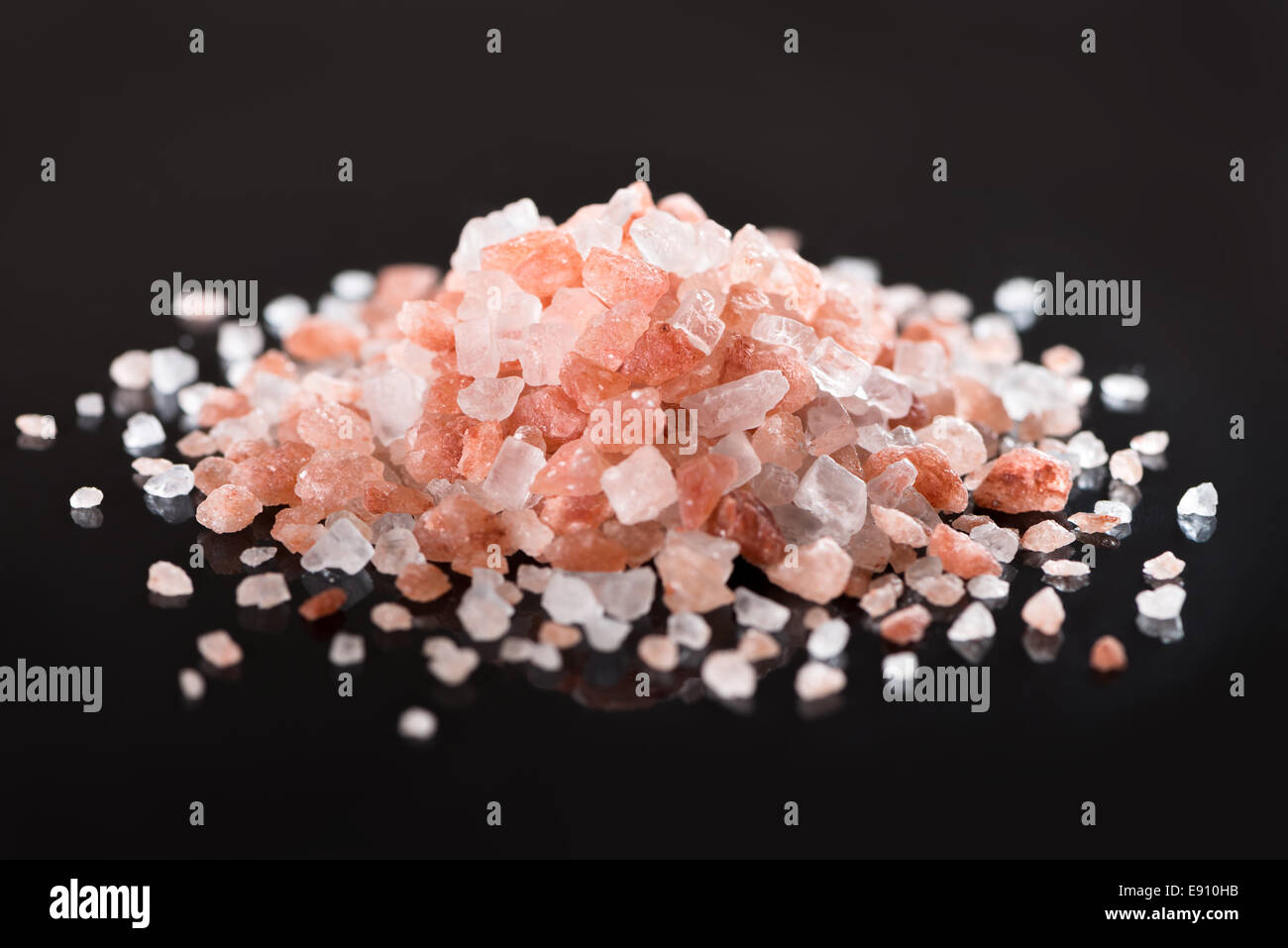 Cumulo di rosa Sale Himalayano su sfondo nero con la riflessione Foto Stock