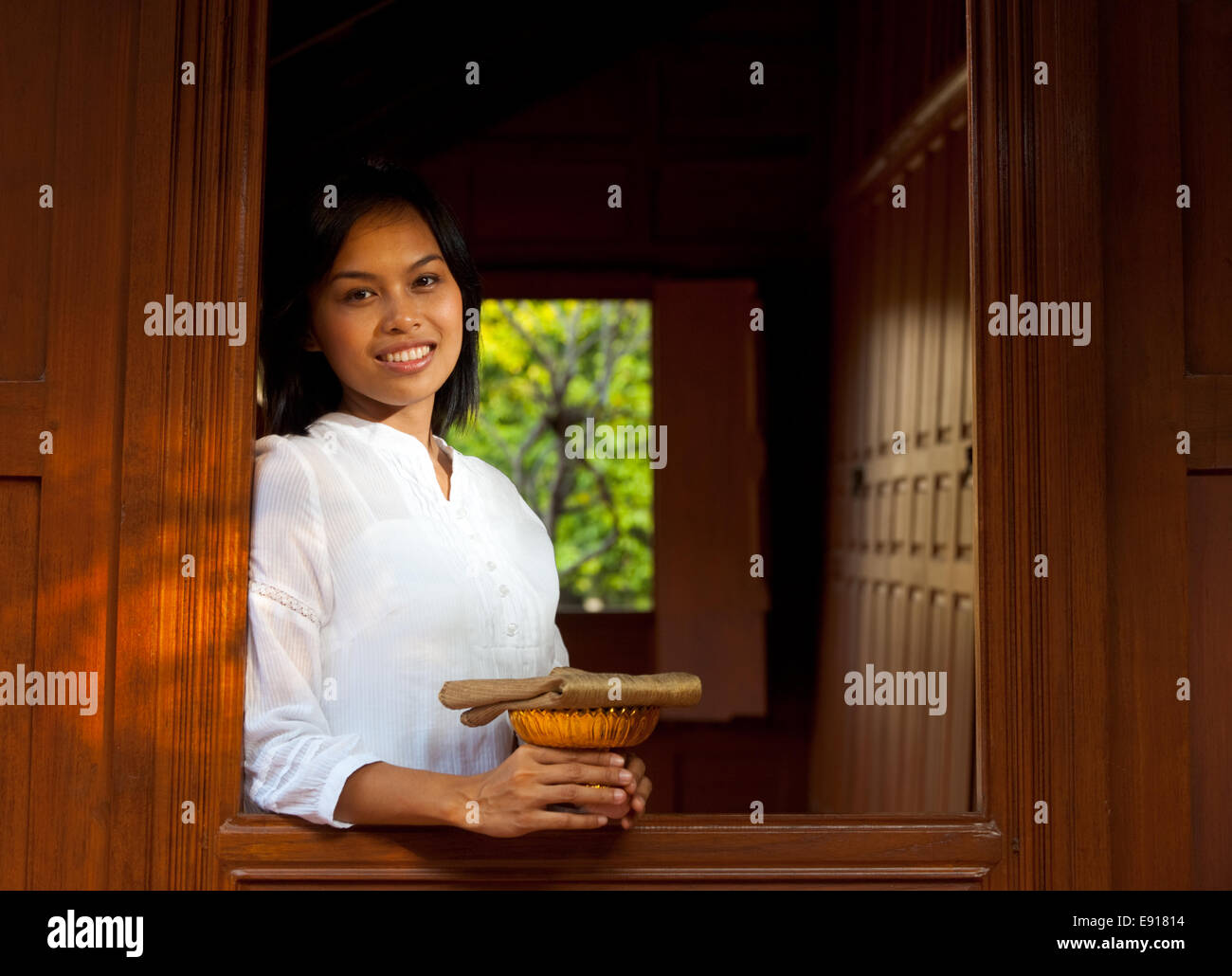 Bella Signora sporgersi in teak tailandese House Foto Stock