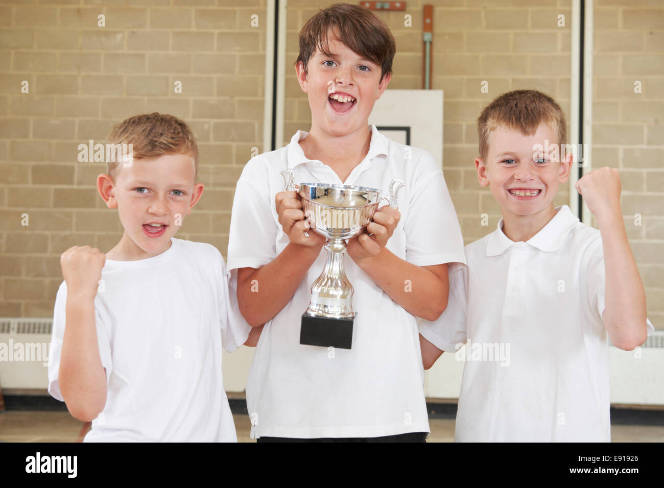 Scuola maschile sport di squadra in palestra con Trophy Foto Stock