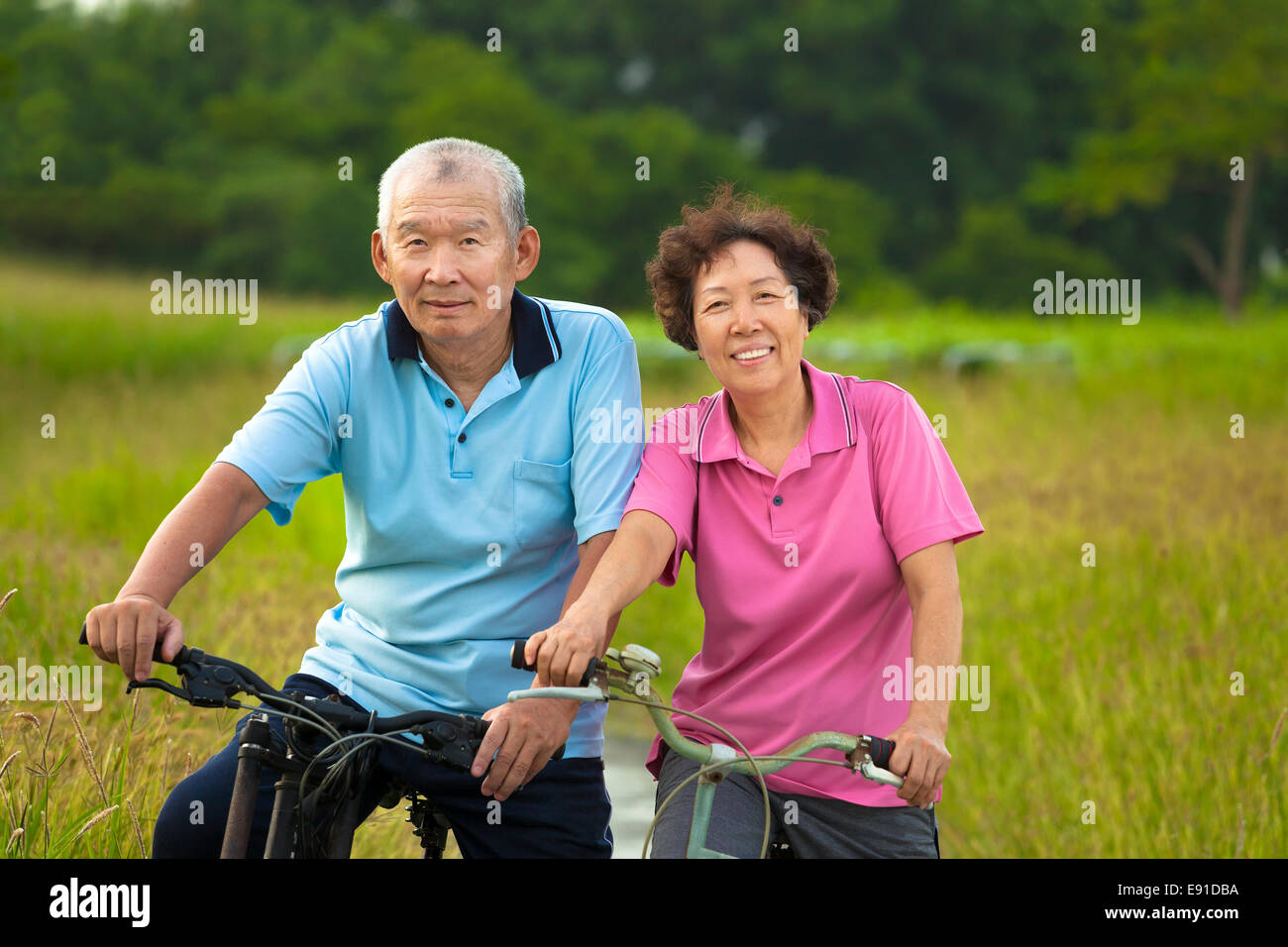 Felice seniors asiatica giovane mountain bike nel Parco. Le pensioni di anzianità e di concetto di salute Foto Stock