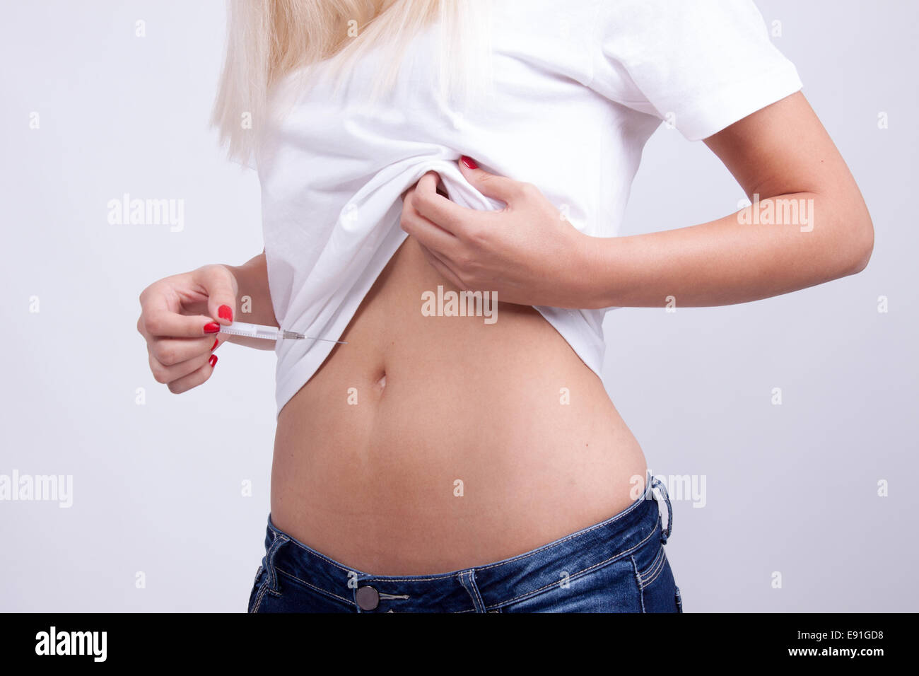 Il Diabete paziente donna fare un addome sottocutanea di siringa di iniezione di insulina Foto Stock