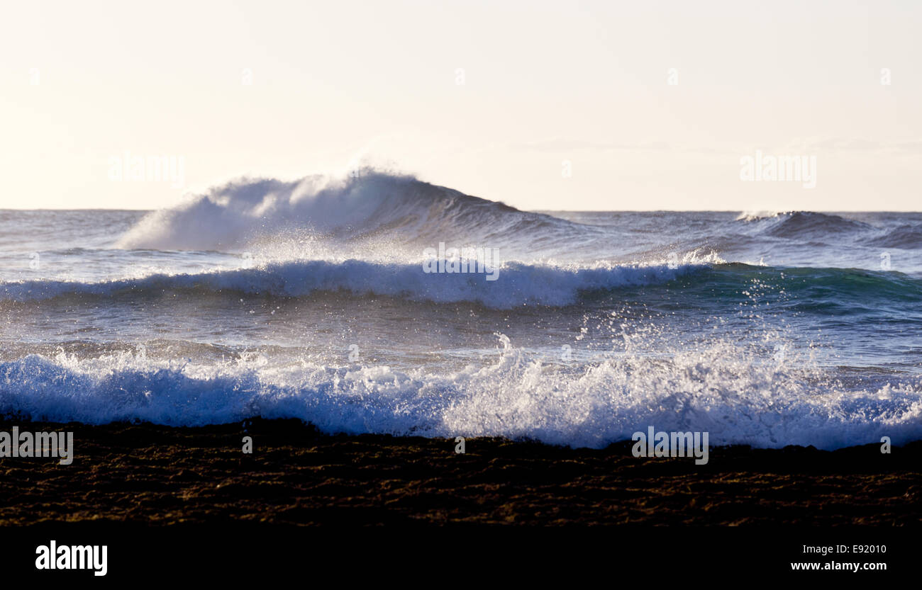 Impostazione sole illumina le onde del mare Foto Stock