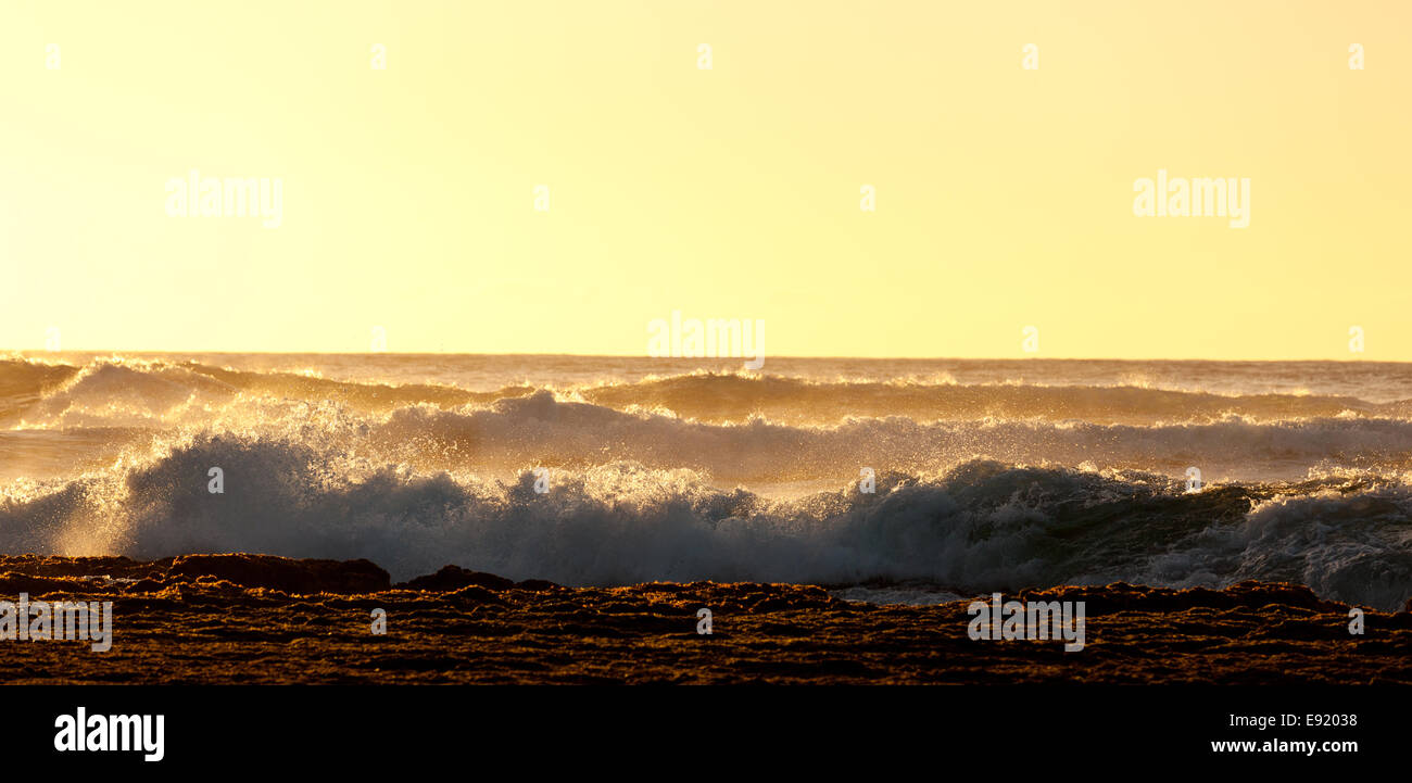 Impostazione sole illumina le onde del mare Foto Stock