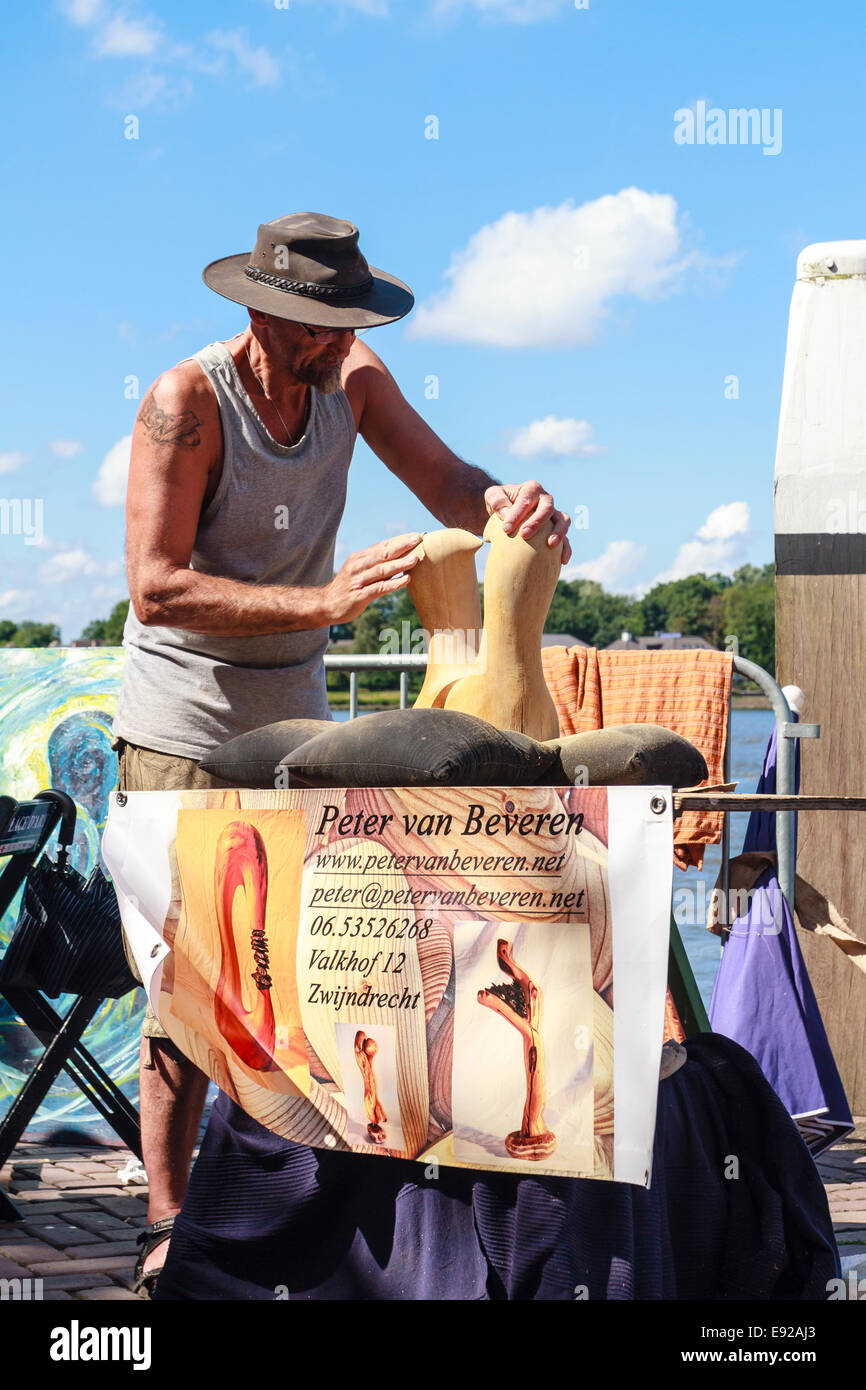 Dordrecht, Paesi Bassi - 11 agosto 2013: l'artista Peter van Beveren levigatura e il suo lavoro di scultura durante il festival. Foto Stock