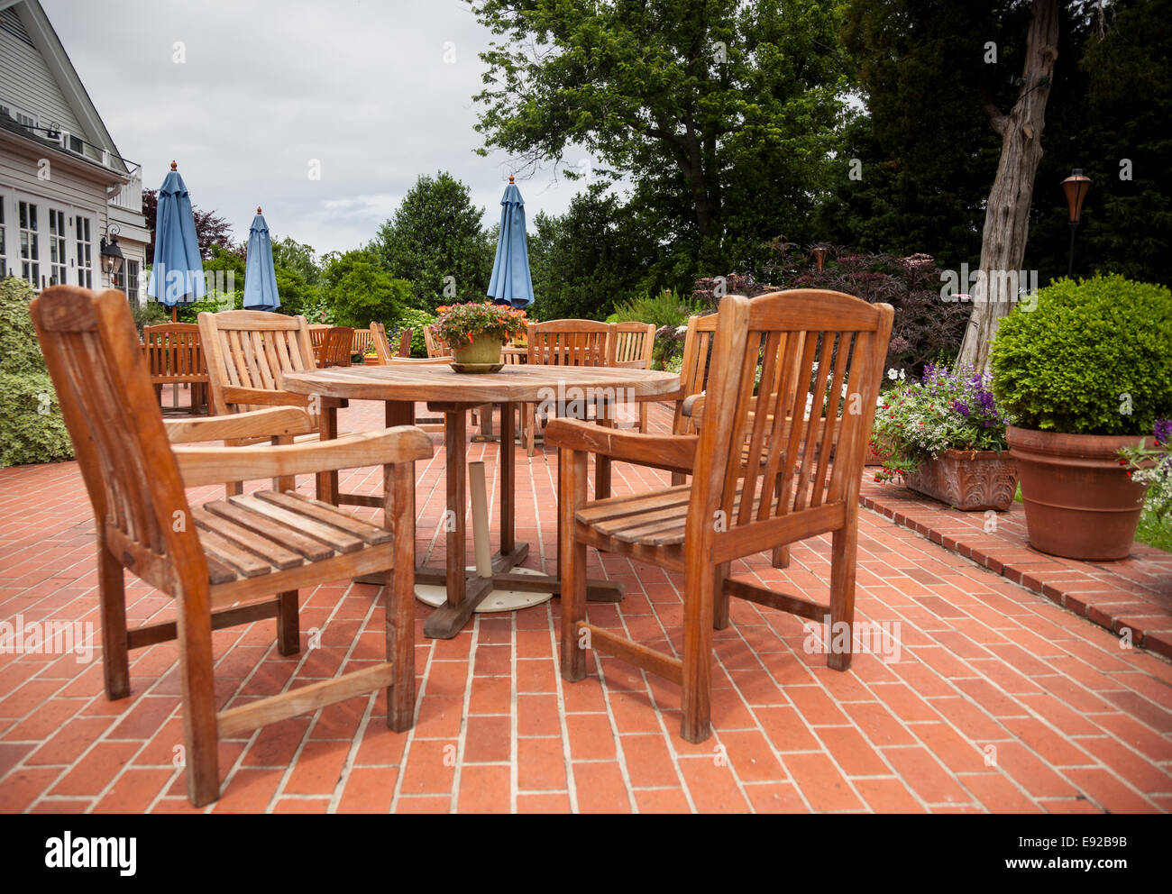 Patio in teak tavoli e sedie sul ponte di mattoni Foto Stock