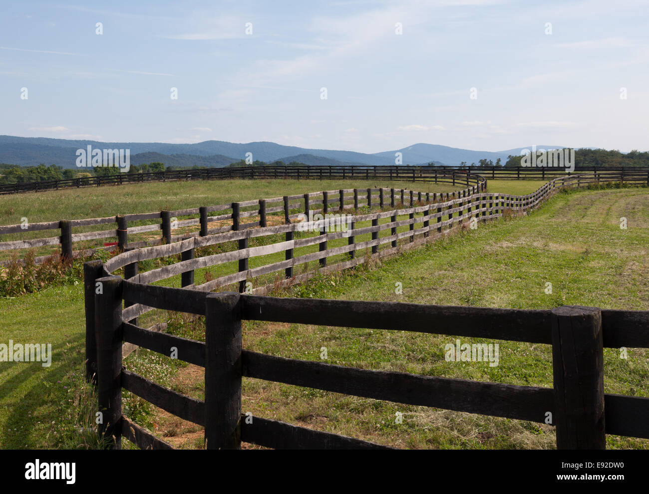 Rolling Meadows con recinti di legno e colline Foto Stock