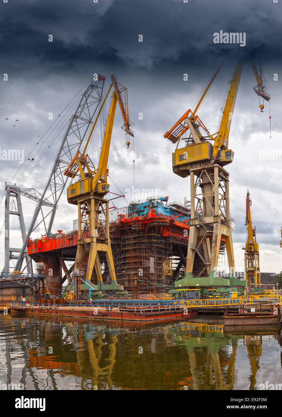 Grande gru industriali su un drammatico sfondo cielo. Foto Stock
