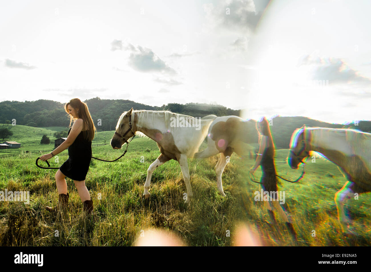 Giovani donne in abito nero passeggiate a cavallo su tutto il campo, doppia esposizione Foto Stock