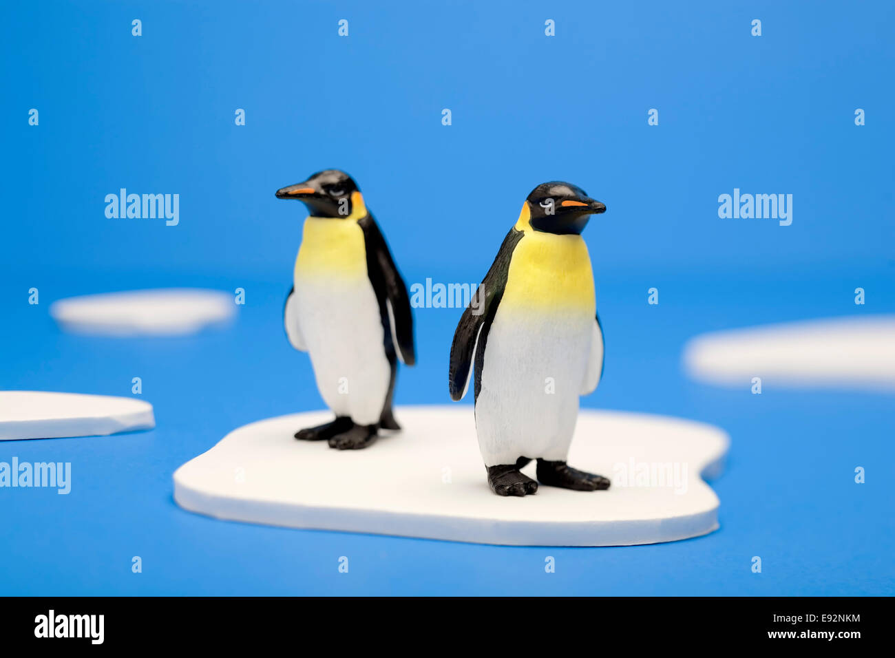 Una illustrazione concettuale che illustra due pinguini in piedi su un piccolo pezzo di ghiaccio nell'Artico. Foto Stock