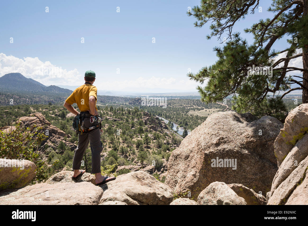 Maschio Senior rocciatore in piedi che si affaccia sulla pianura della valle di Turtle rocce vicino Buena Vista, Colorado, STATI UNITI D'AMERICA Foto Stock