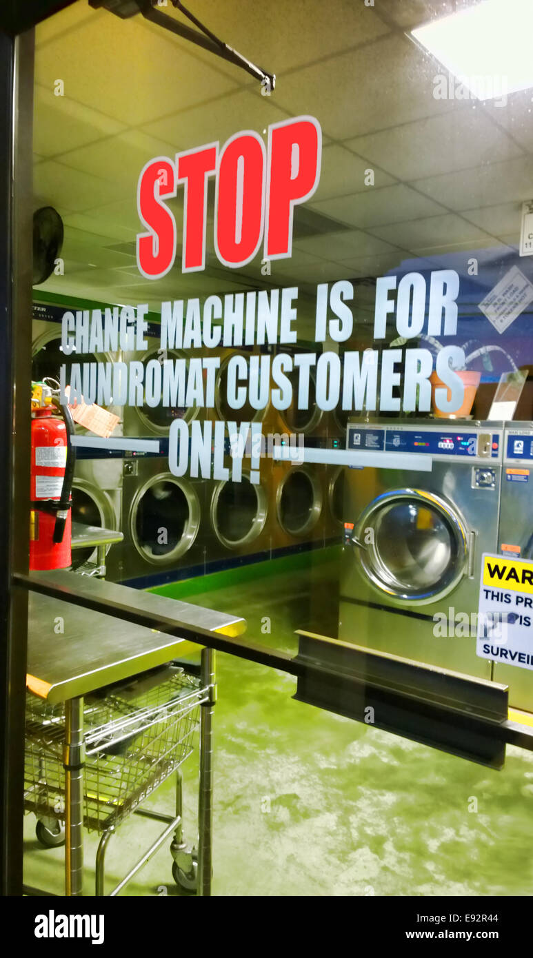 Segno su una finestra di laundromat di notte Foto Stock