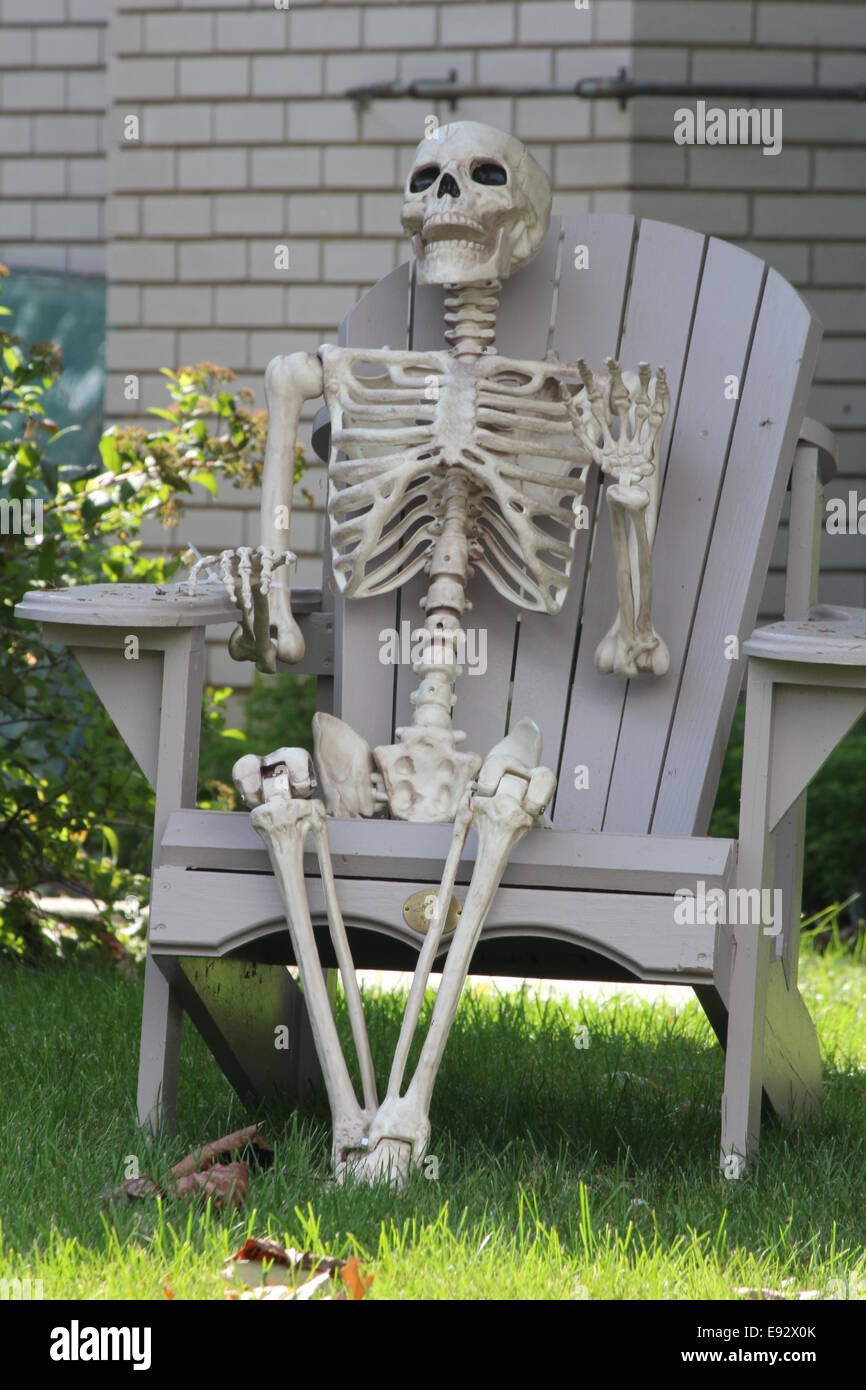 Una plastica, decorativo, imitazione di uno scheletro umano seduto in una  sedia di cantiere, in preparazione per la festa di Halloween Foto stock -  Alamy