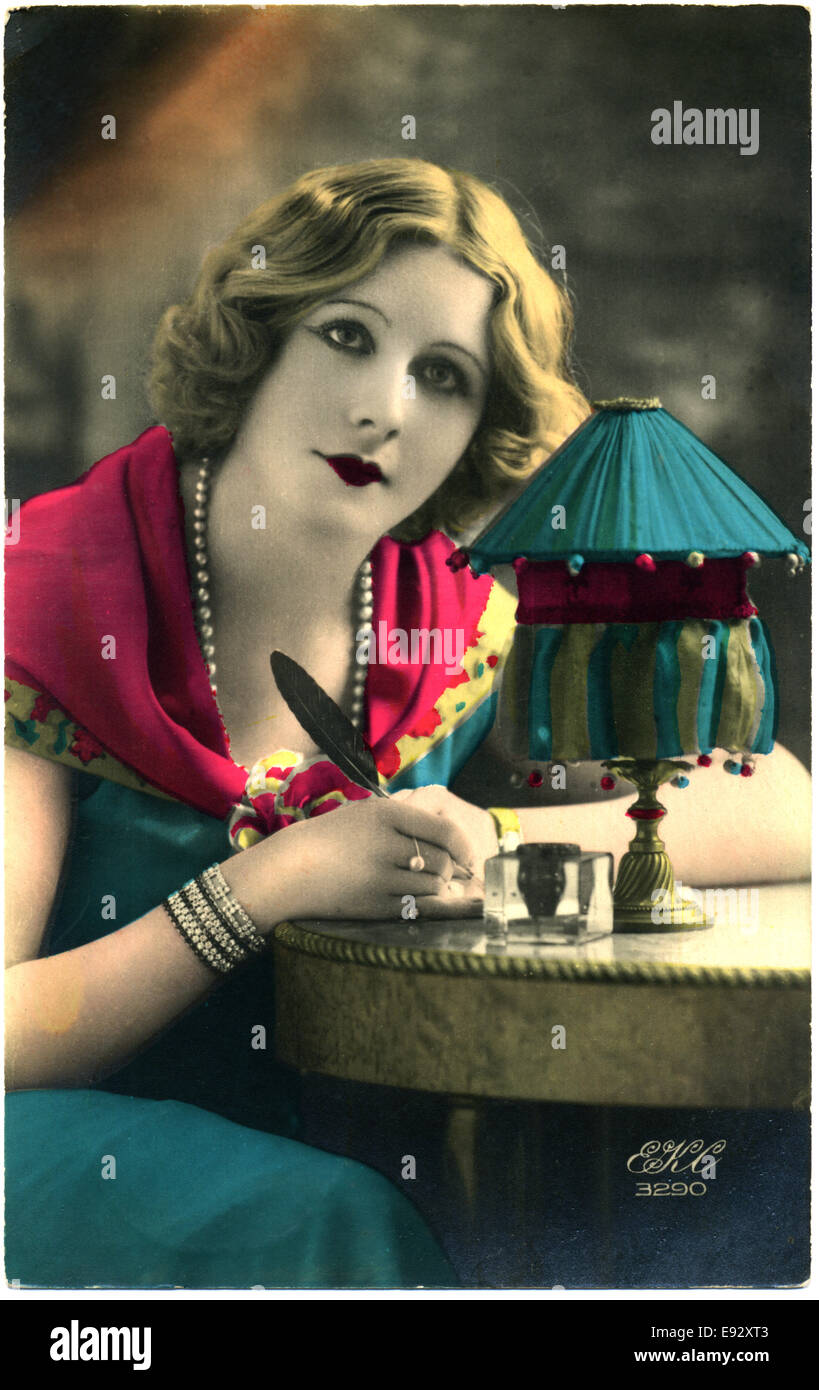Donna in vestito blu seduto alla scrivania scrivere lettera con la penna del cappello, Hand-Colored, Francese cartolina, circa 1910's Foto Stock