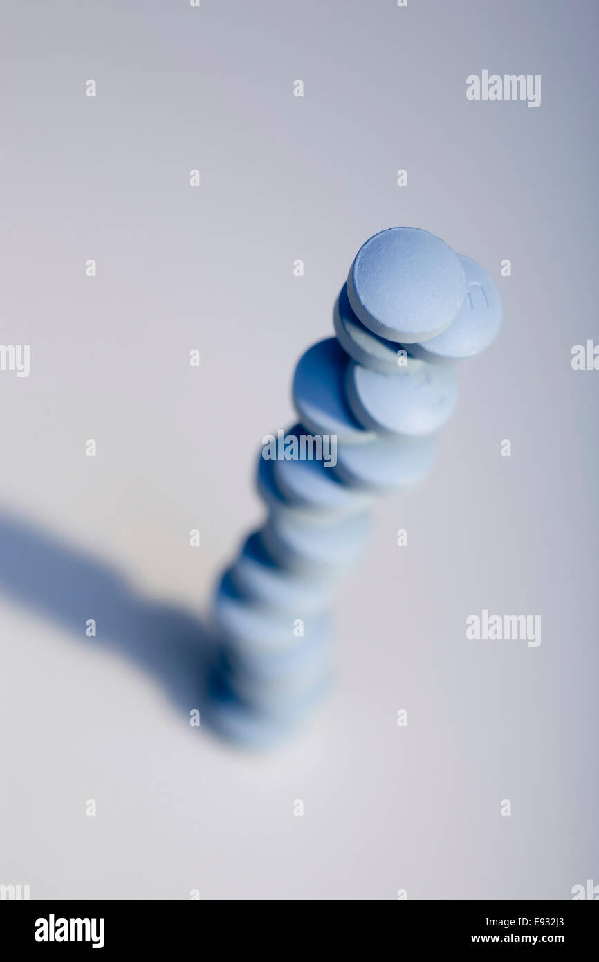 Angolo alto in prospettiva di una pila di blu pillole di prescrizione. Profondità di campo. Immagine concettuale. Foto Stock