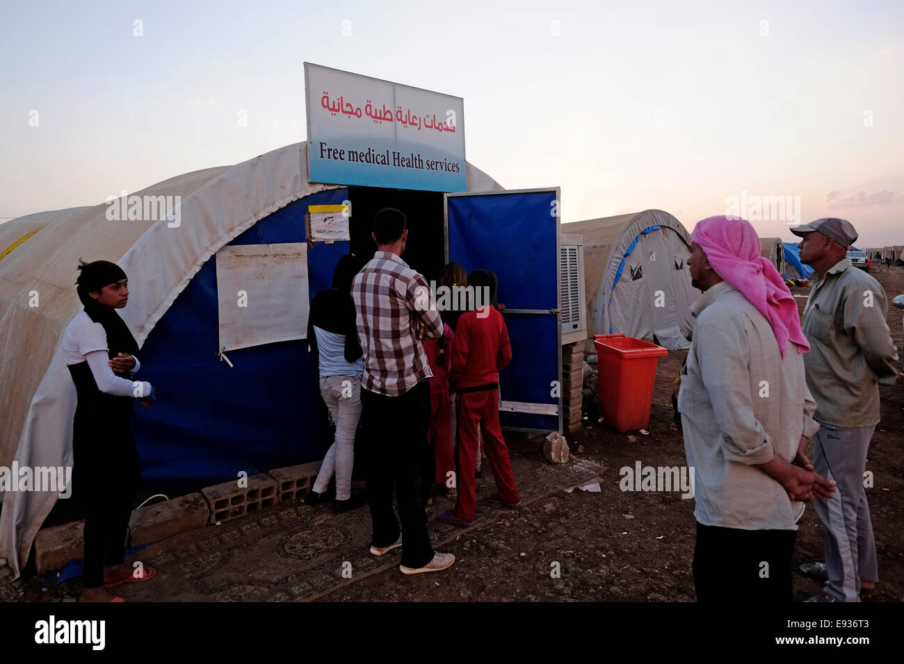 Yazidi di persone in coda per entrare in un mobile di clinica medica in Nawroz Refugee Camp che è stata inizialmente istituita per shelter Aramei spostato dall'attuale siria guerra civile poi occupata dagli sfollati dalla minoranza setta Yazidi, che fuggono dalla violenza nella città irachena di Sinjar situato vicino alla città di al-Malikyah in Rojava autonoma curda, regione nord-orientale della Siria. Foto Stock
