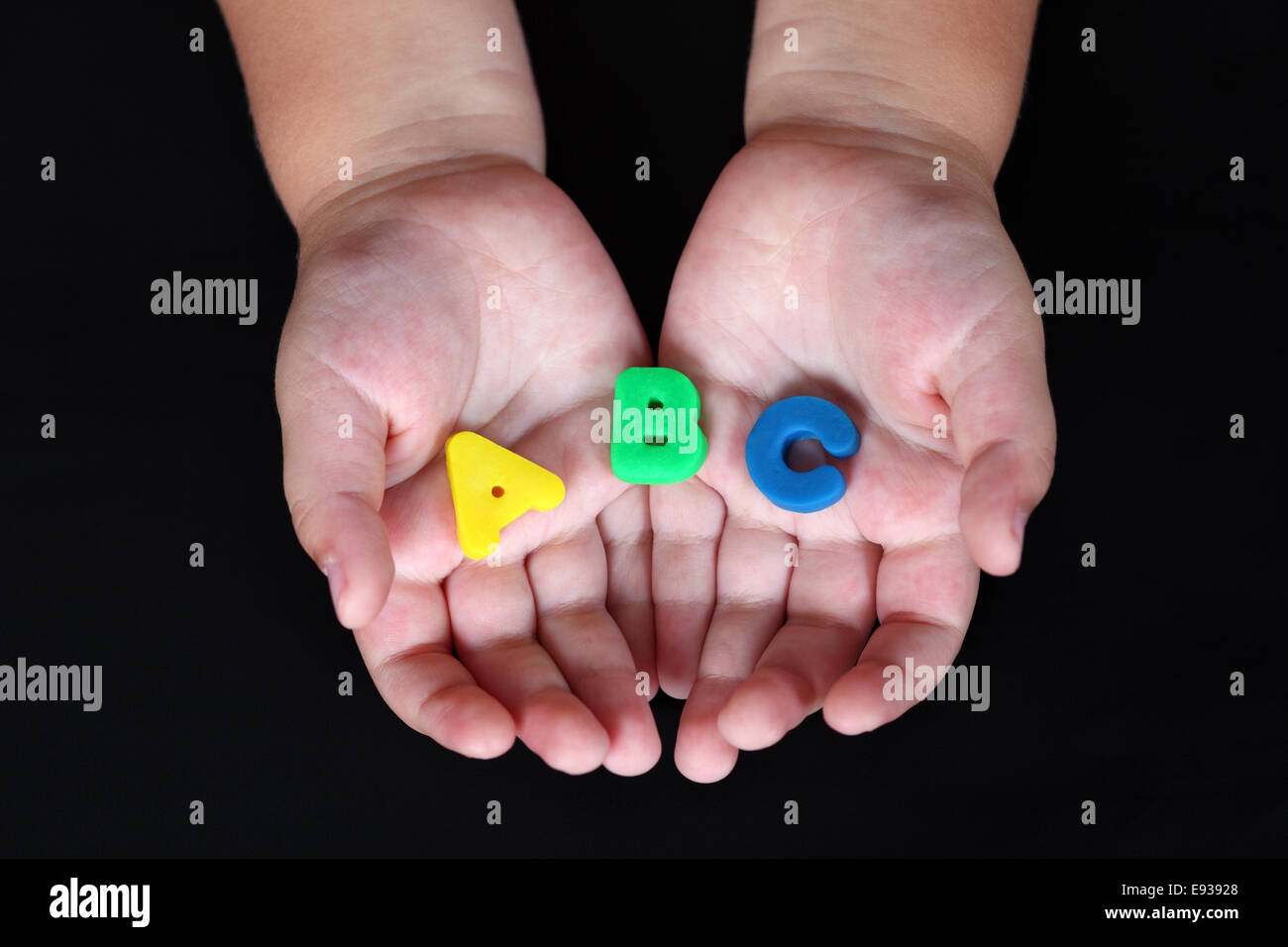 ABC nel bambino le mani su sfondo nero. Foto Stock