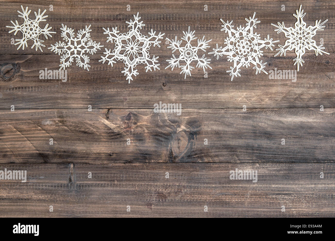 I fiocchi di neve oltre confine in legno rustico sfondo. Decorazione di natale Foto Stock