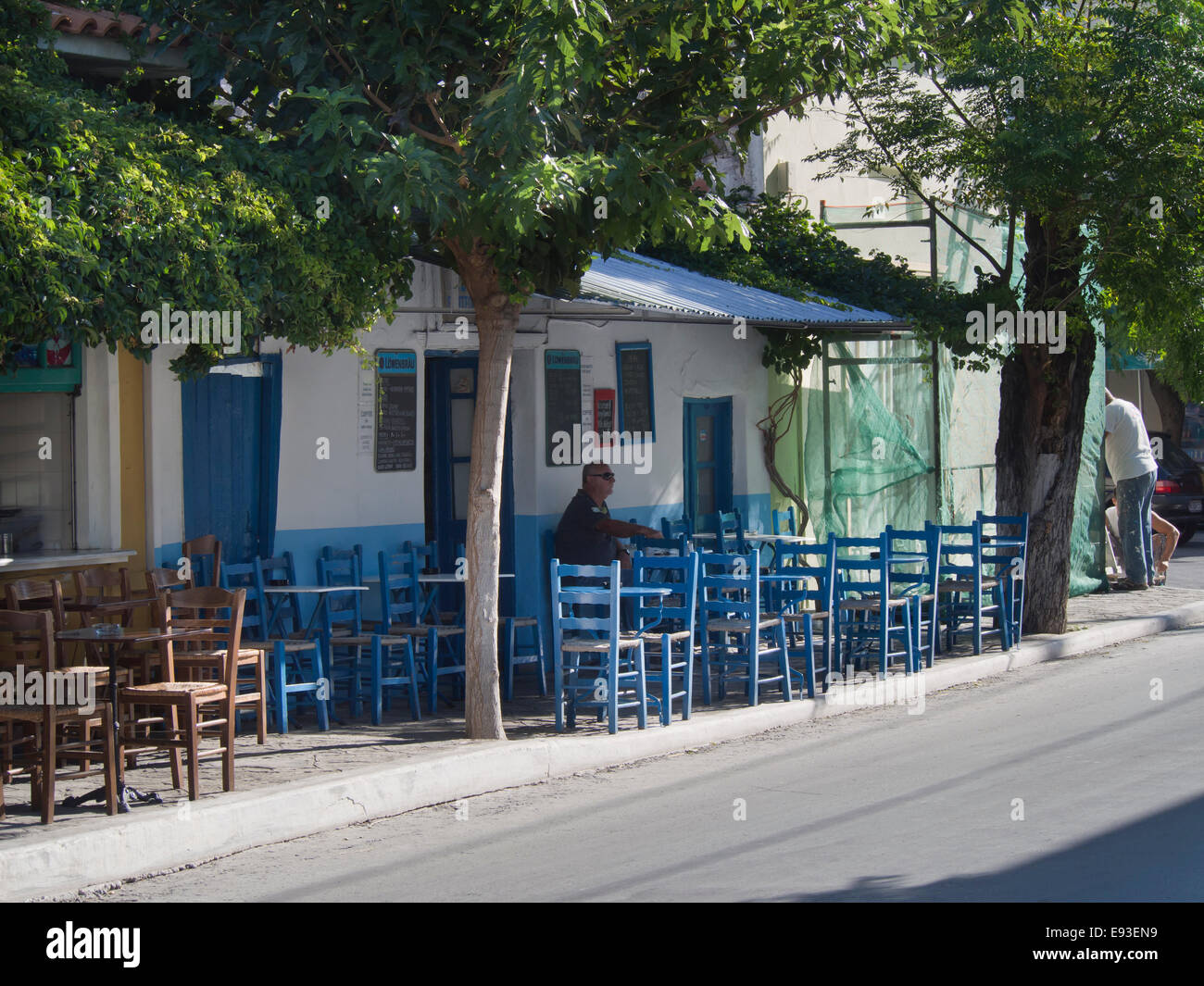 Tipico greco marciapiede café e colorati di blu di tavoli in legno e sedie, villaggio di Pythagoreion nell'isola di Samos Grecia Foto Stock
