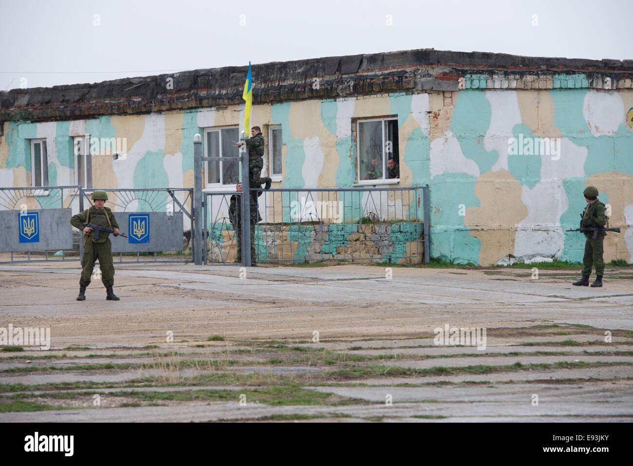 Avieri ucraino provocatoriamente sollevare una bandiera sotto l'occhio vigile delle armate russe truppe, Belbek airbase Ucraina Foto Stock