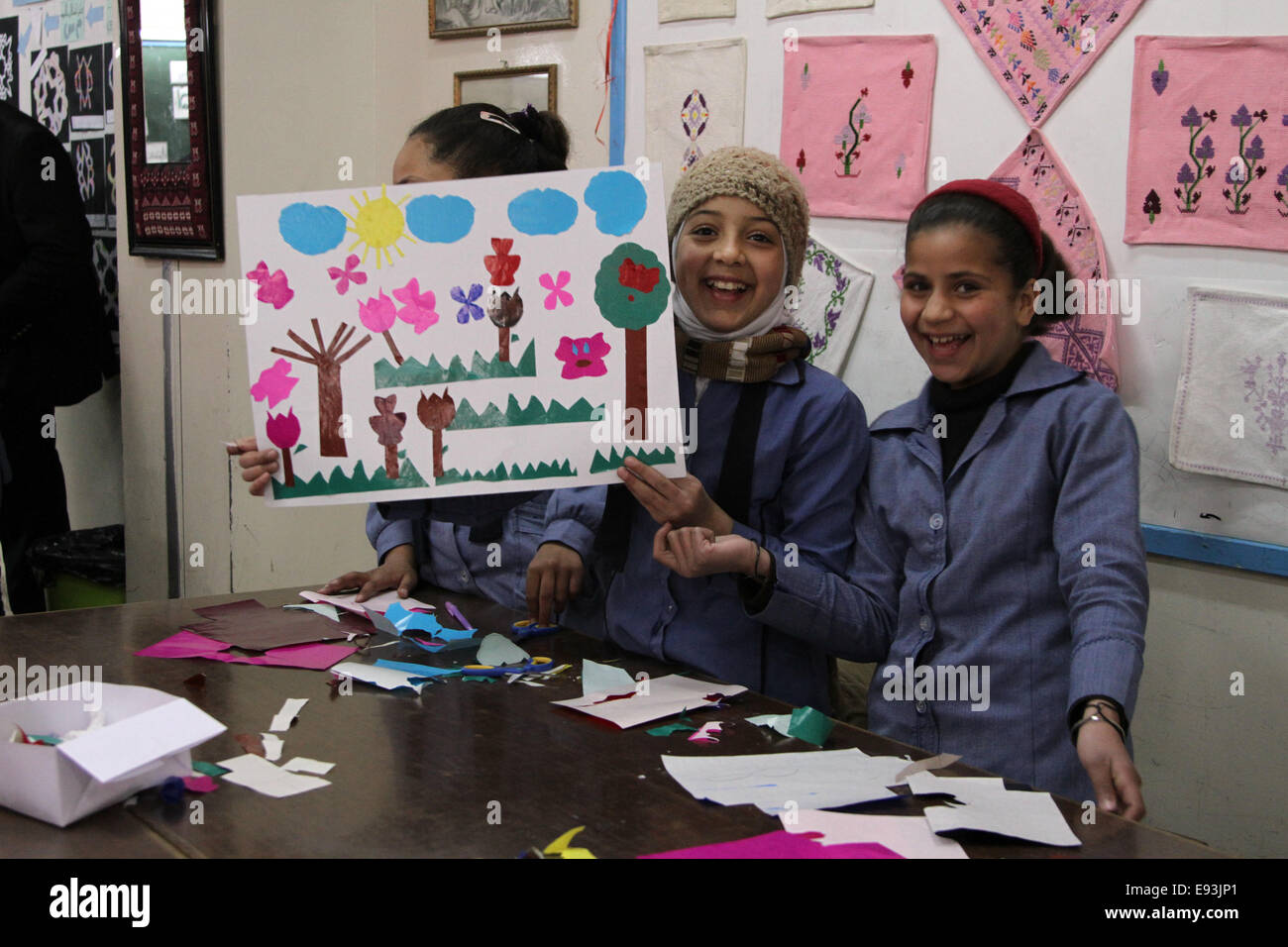 Gli alunni hanno alzato le loro opere d'arte in un'aula presso l'elementare Educandato n. 2 in Irbid campo profughi palestinese, Giordania Foto Stock
