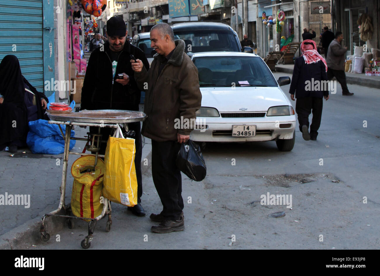 Due uomini ridere mentre controllare i loro telefoni cellulari nel centro di Amman in Giordania Foto Stock