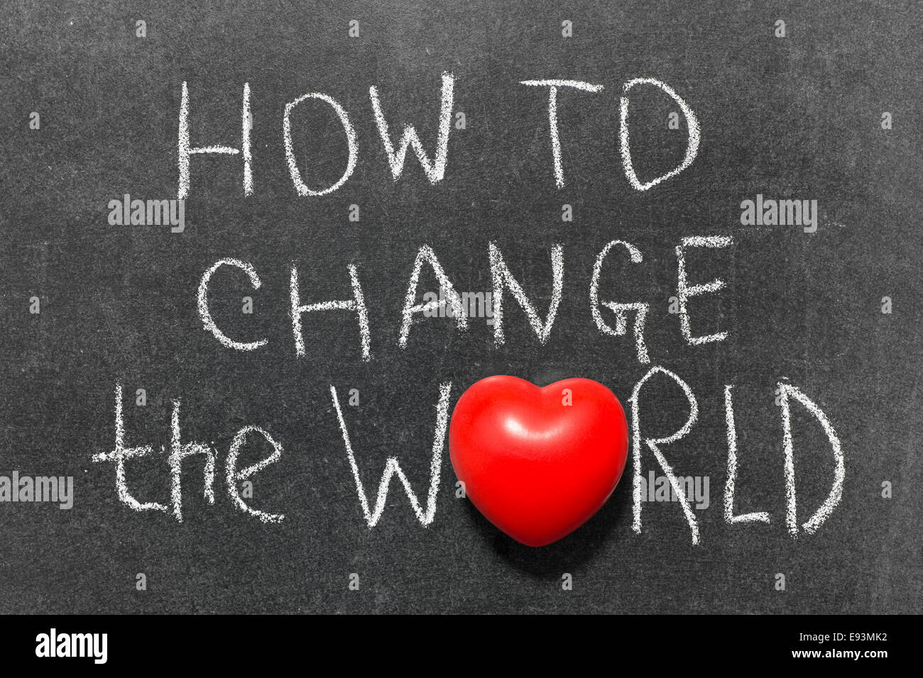 Come cambiare il mondo una frase scritta a mano sulla lavagna con il simbolo del cuore di invece di o Foto Stock