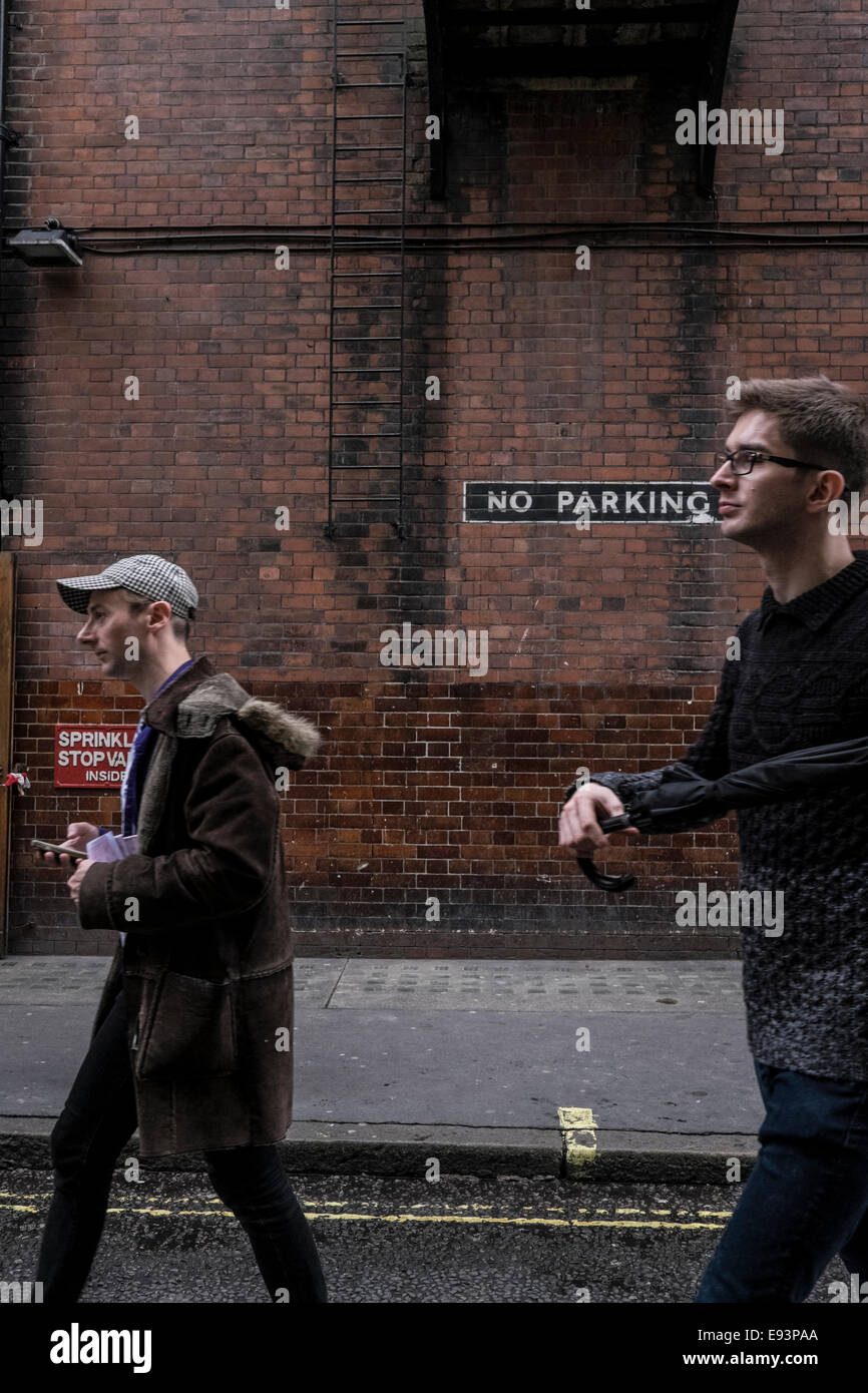 Due uomini a piedi lungo una Londra back street in Soho Foto Stock