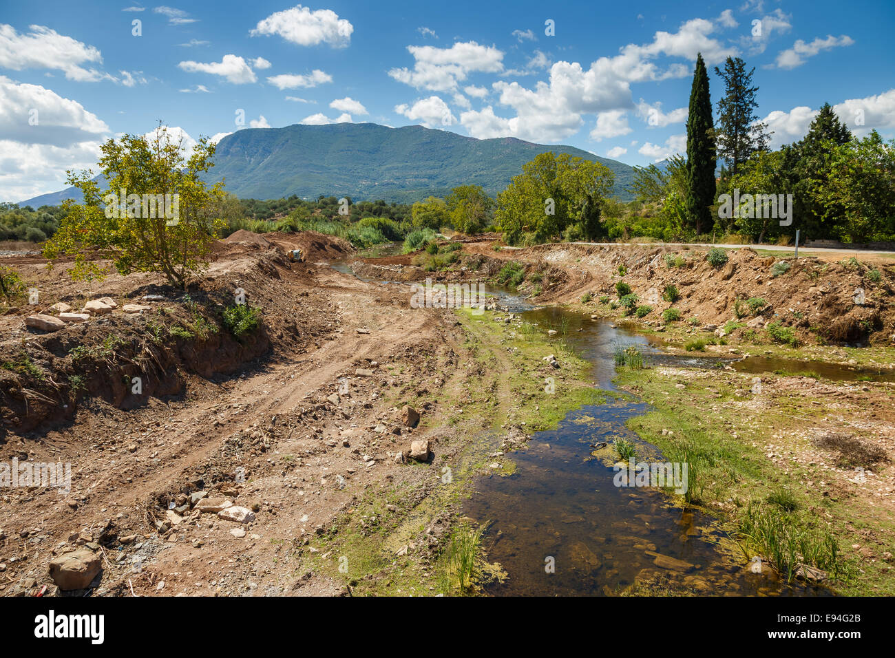 Sito in costruzione contro un cielo blu in Grecia con la sporcizia e la terra scavata in primo piano. Lavori generali di costruzione scena Foto Stock