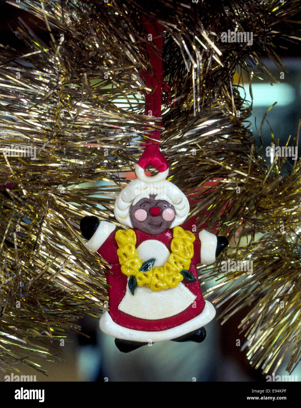 Un colorato pane pasta-Hawaiian Santa Claus ornamento con una ghirlanda di fiori di giallo intorno al suo collo pende in un albero di Natale a Honolulu, Hawaii, Stati Uniti d'America. Foto Stock