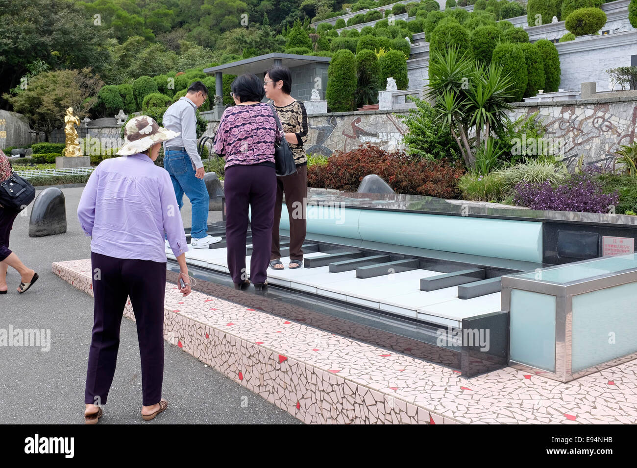 I turisti in piedi su un gigantesco pianoforte presso la tomba del cantante cinese Teresa Teng in Jinshan, Nuova Citta' di Taipei, Taiwan Foto Stock