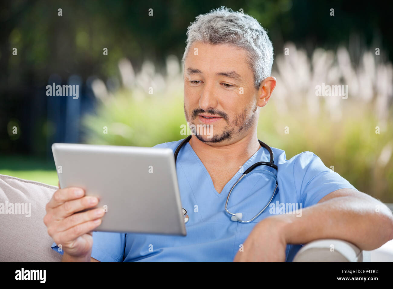 Medico maschio guardando un tablet pc Foto Stock