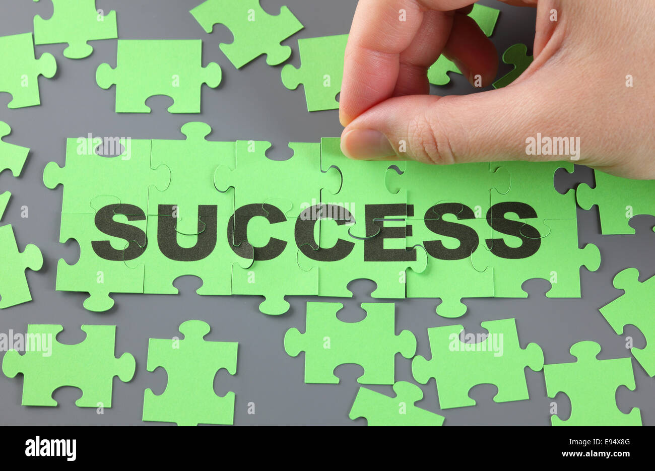 Donna di mano completando puzzle con la parola 'Success'. Foto Stock