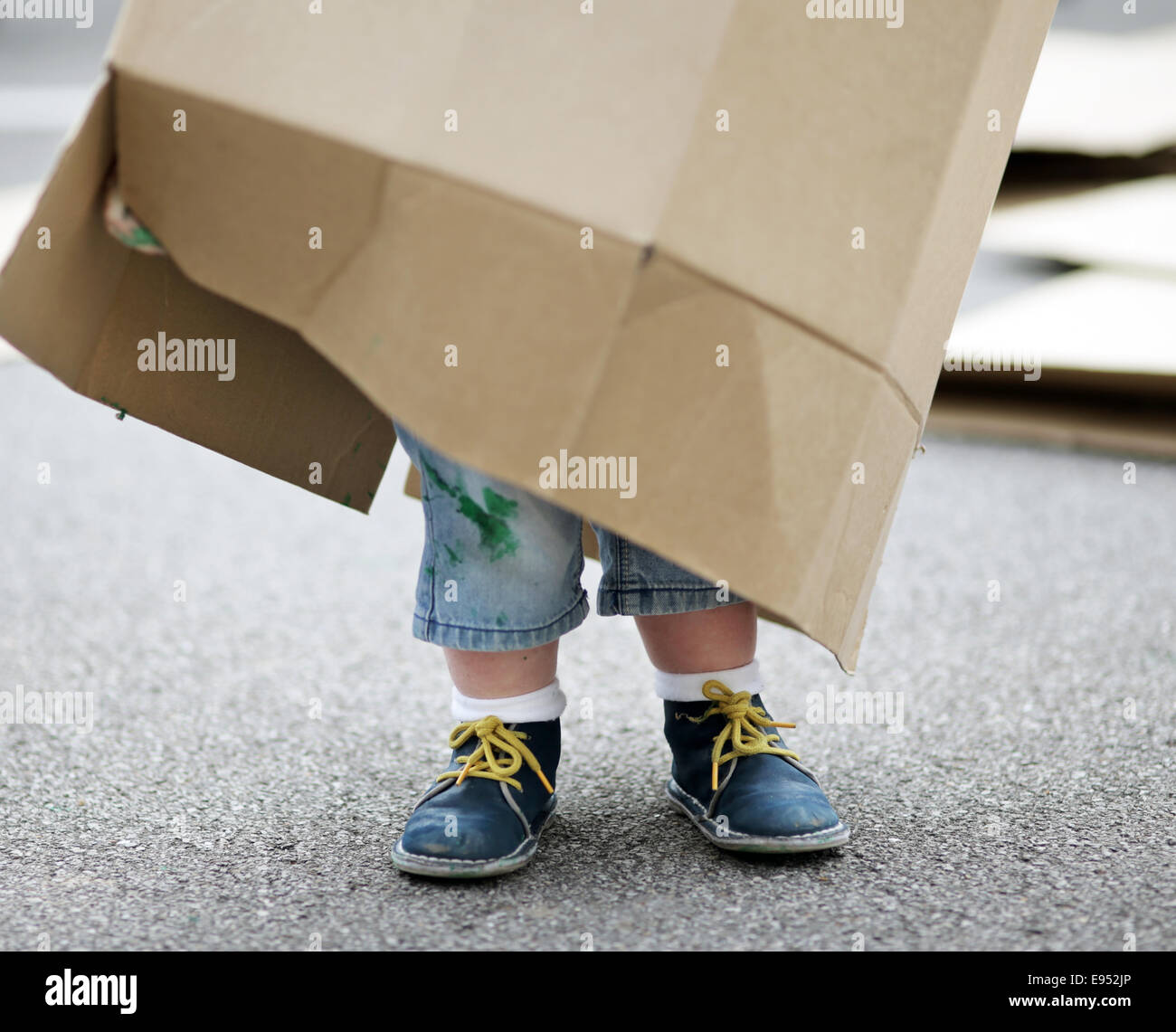Un bambino che gioca con una scatola di cartone. Foto Stock