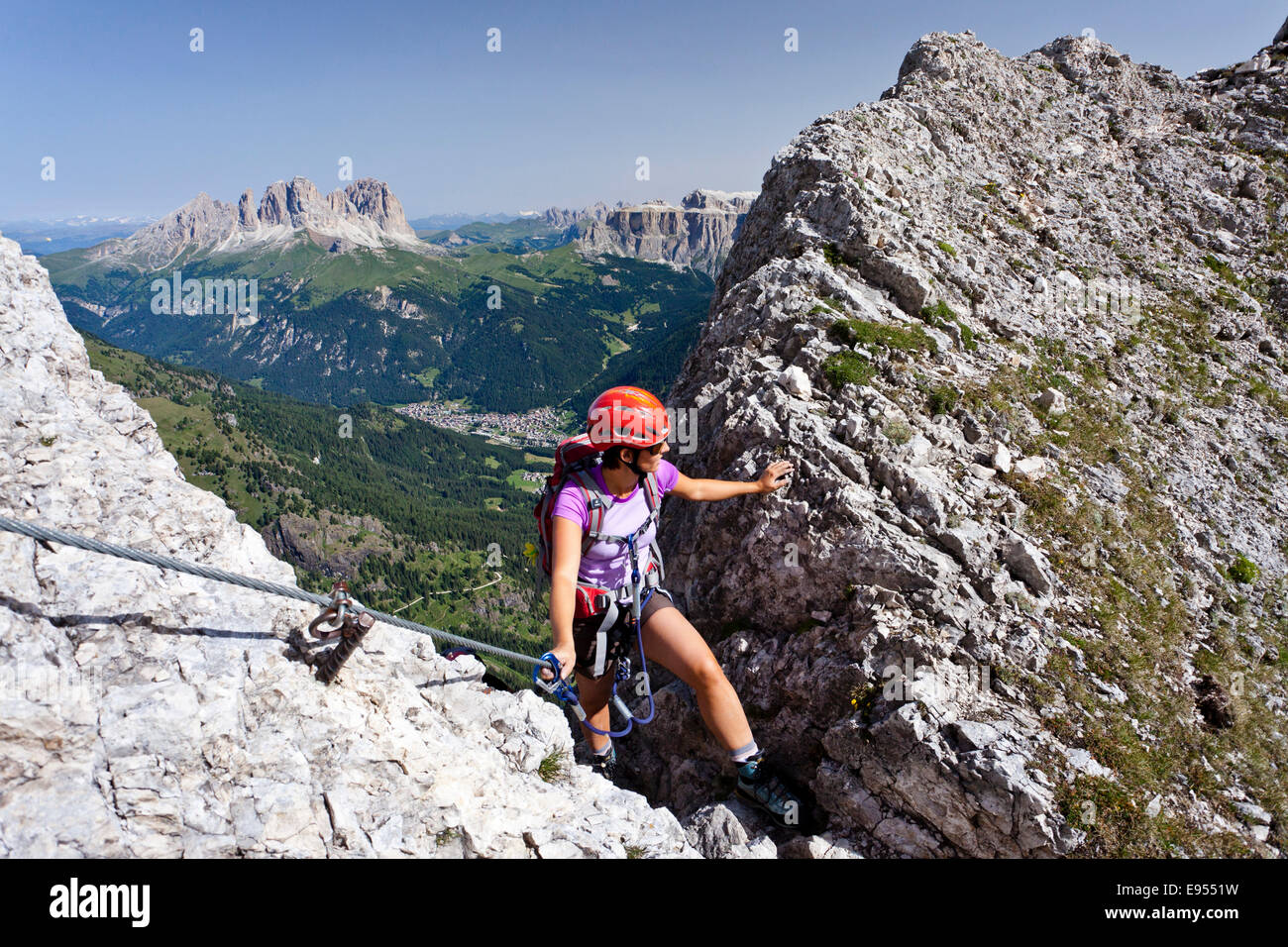 Scalatore ascendente sulla Via ferrata dei finanzieri alla sommità del Colac, Sasso Lungo e Sasso Piatto nella parte posteriore Foto Stock