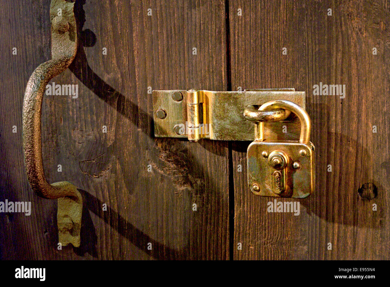 Vecchia porta di legno bloccato con raccordi di metallo e un lucchetto Foto Stock