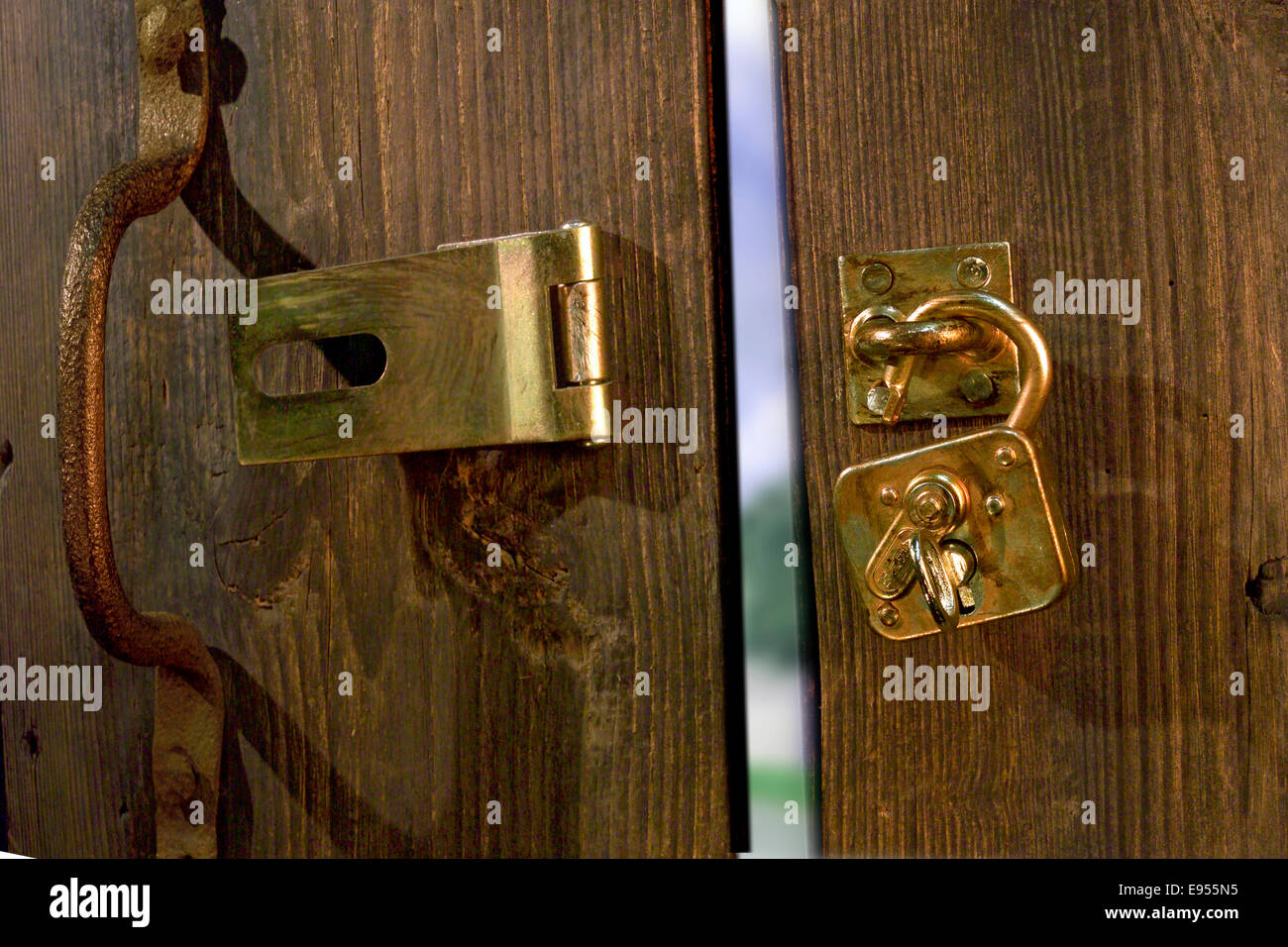 Vecchia porta in legno con finiture in metallo e un lucchetto aperto Foto Stock