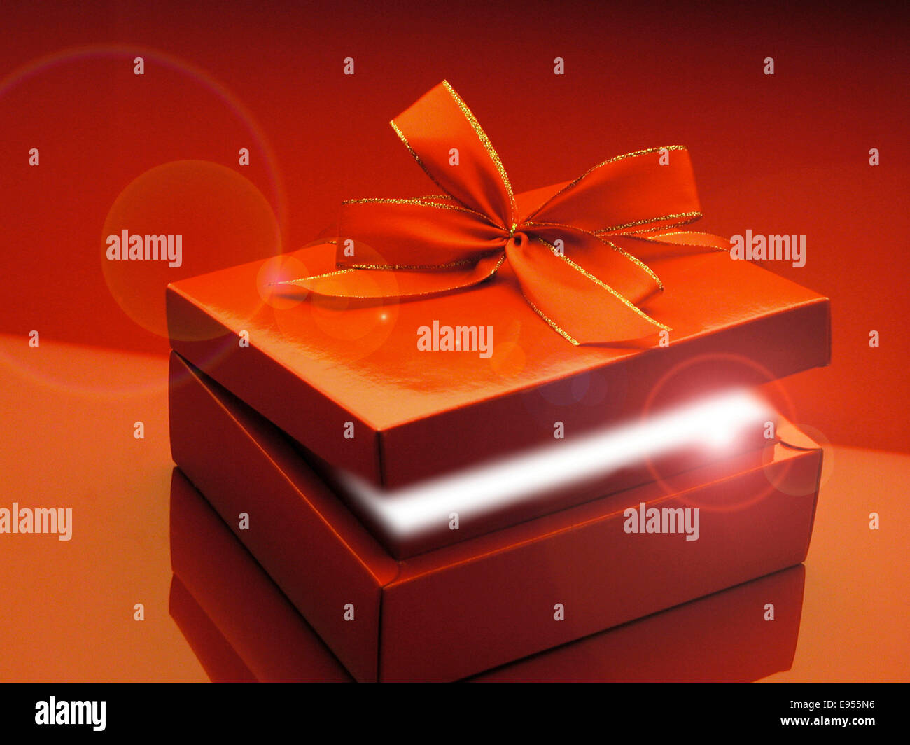 Confezione regalo rossa con nastro, dalla confezione regalo emerge un raggio di luce Foto Stock