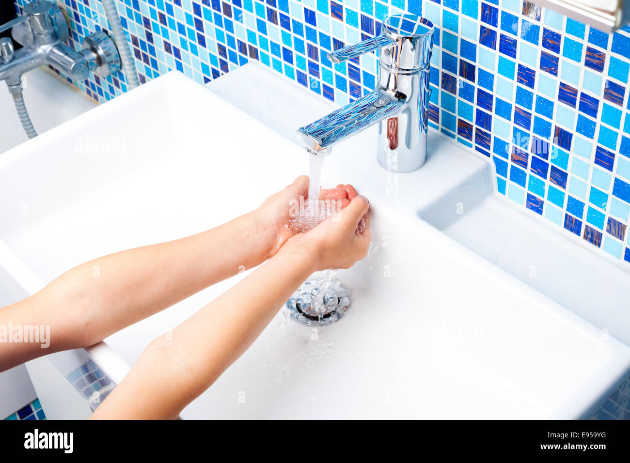 Ragazza lavando le mani nel lavandino del bagno Foto Stock