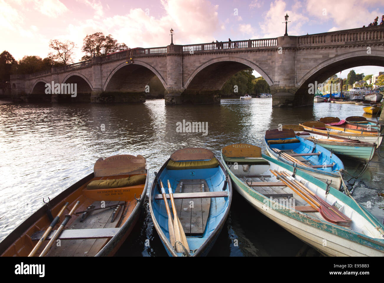 Il piacere di legno barche ormeggiate al fianco di Richmond Bridge sul fiume Tamigi, Richmond Upon Thames, Greater London, Regno Unito Foto Stock