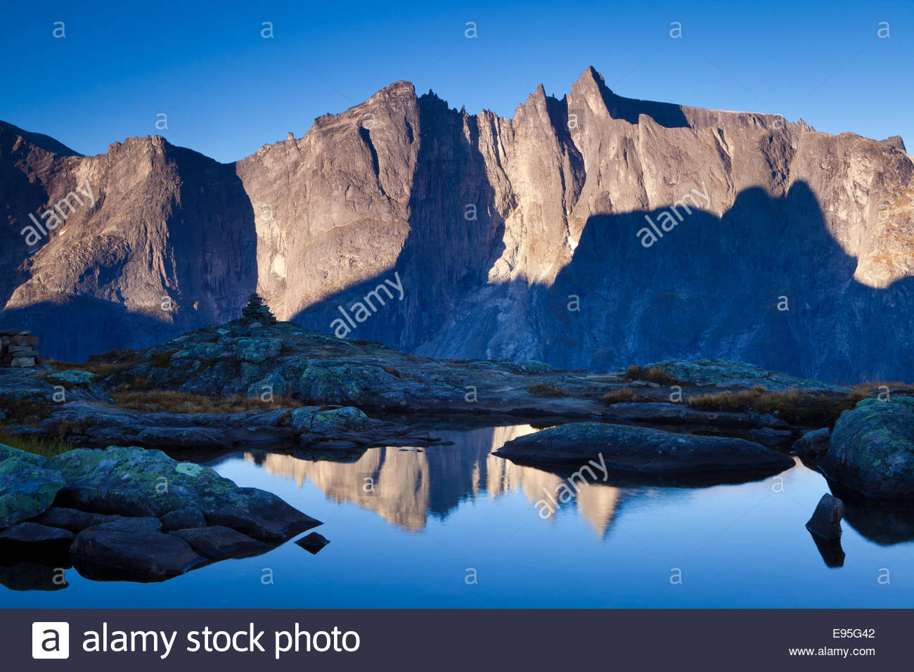 La prima luce sui picchi Trolltindane e il 3000 piedi verticale Parete Troll nella valle Romsdalen, Norvegia. Foto Stock