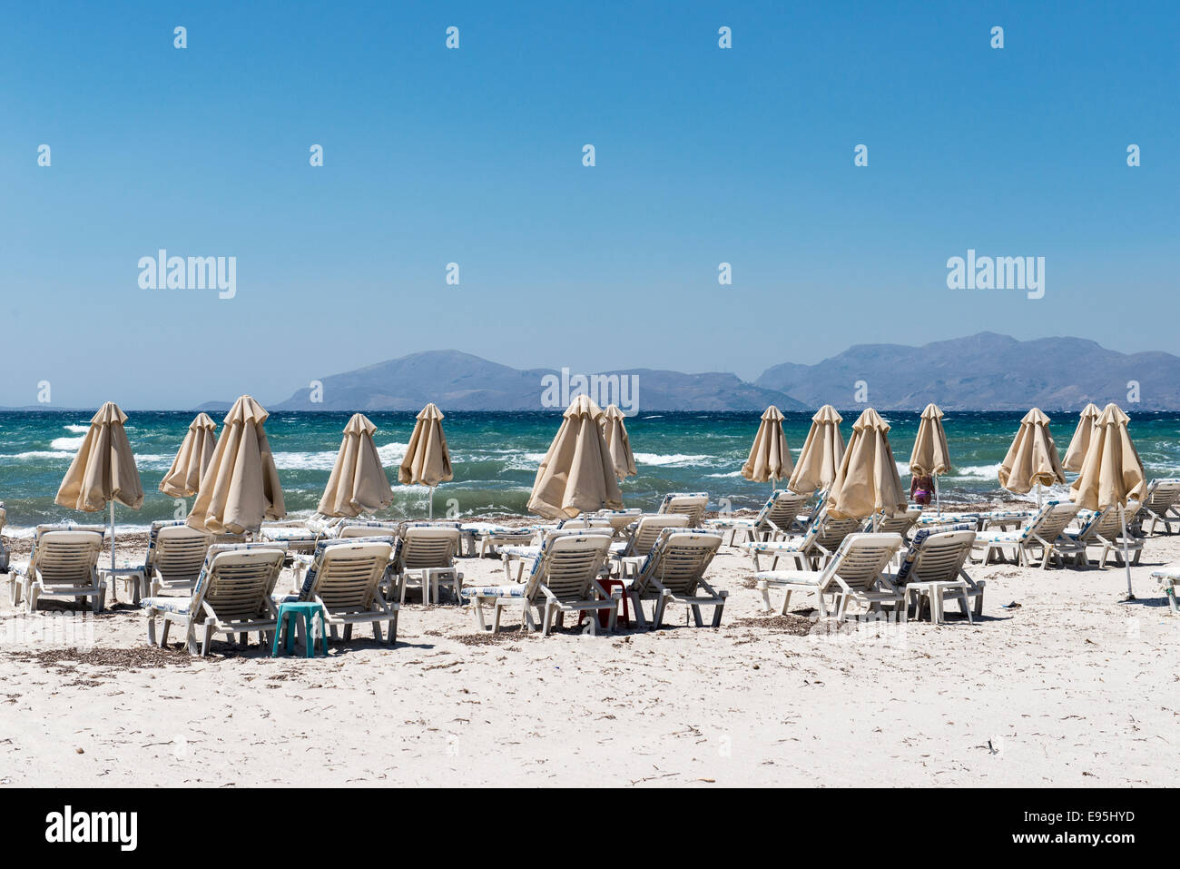 Spiaggia vuota chiusa con ombrelloni e sedie a sdraio sulla spiaggia di Mastichari, isola di Kos, Grecia Foto Stock