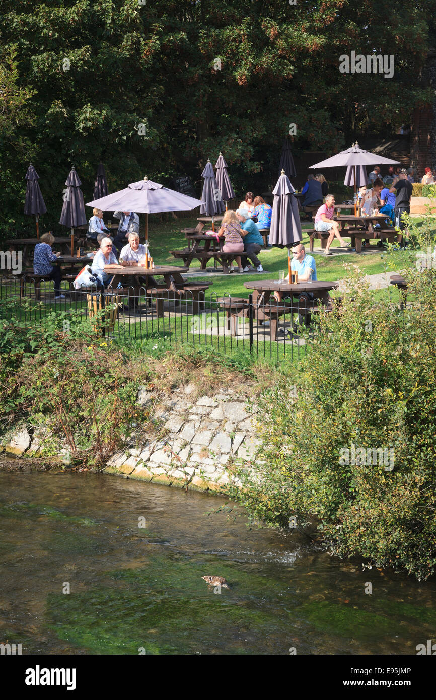 I clienti seduti ai tavoli al di fuori di un pub godendo il sole dal fiume Foto Stock