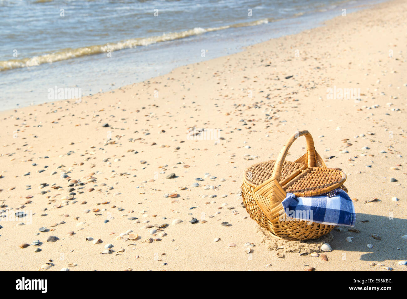 Cesto per pic-nic con blu panno controllati in spiaggia Foto Stock